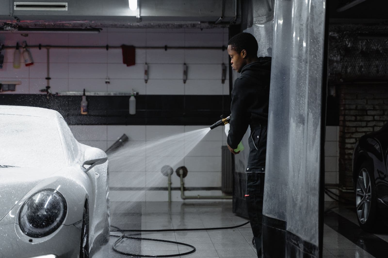 Low-pressure lance cleaning a car inside a parking structure