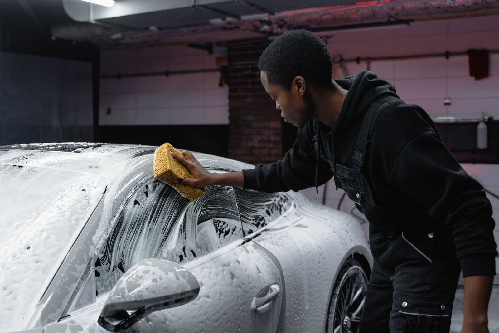 Hand washing the flank of a luxury car with a soft applicator