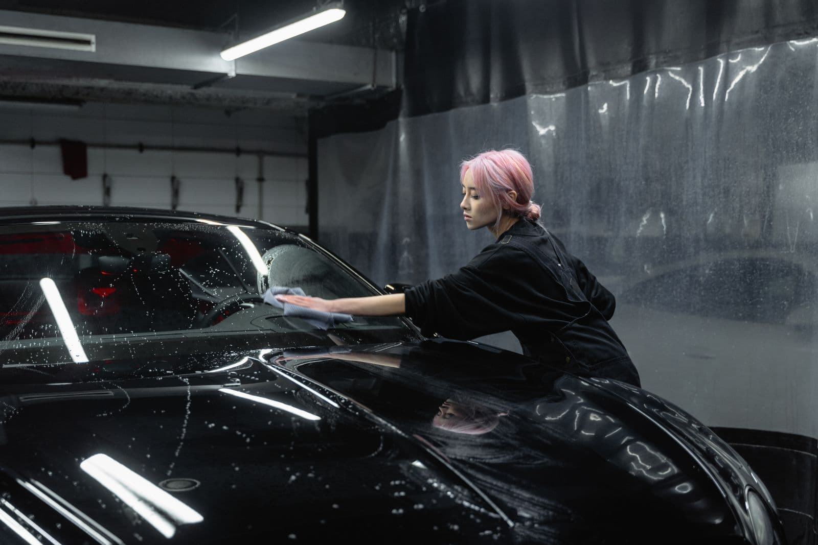 Plush microfibre towel wiping a black car panel dry